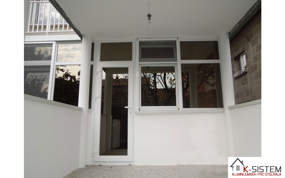 Zastakljena terasa sa ulaznim vratima,fiksnim elementima ,kipovima i jednokrilnim prozorima sa rolo komarnikom
